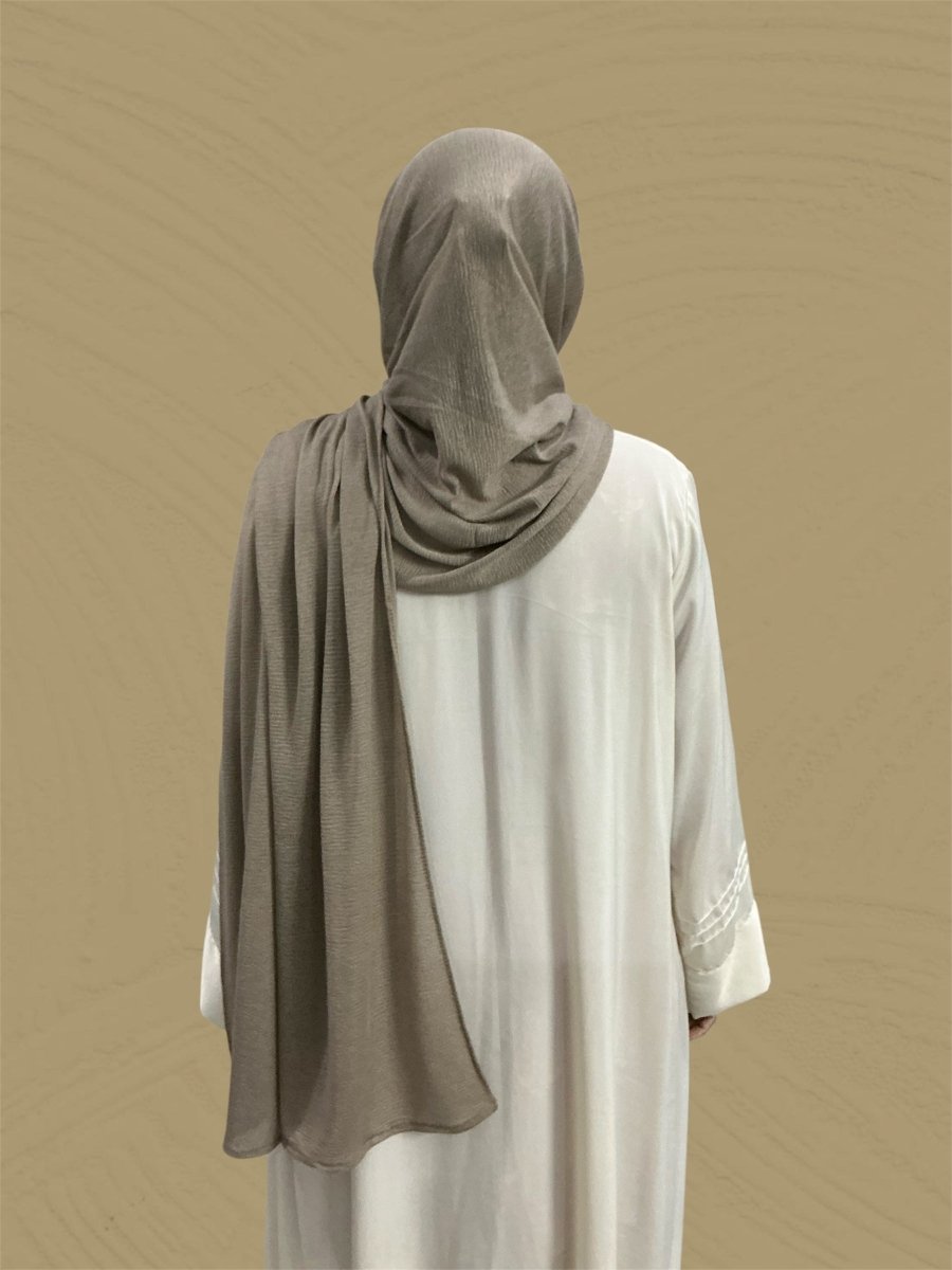 Back view of a person wearing the Crush Jersey Hijab - Cheshire Brown with a stylish drape.